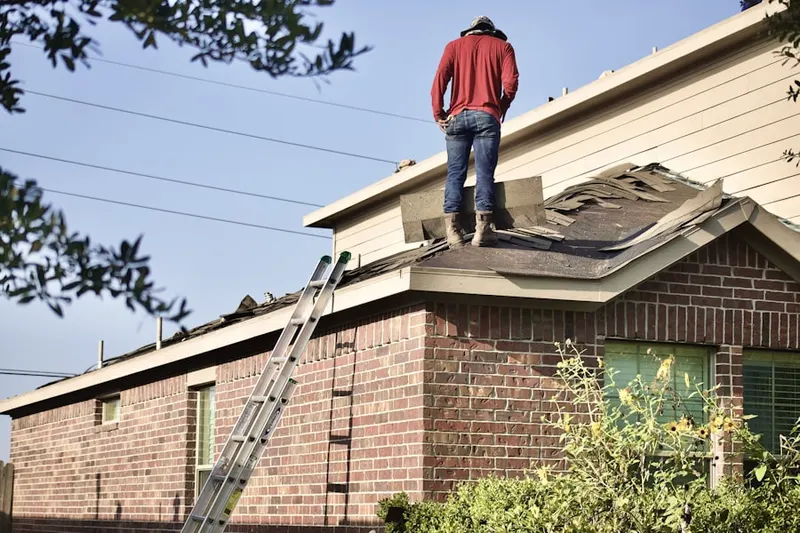 Professional roofer working on a residential roof in The Hollow